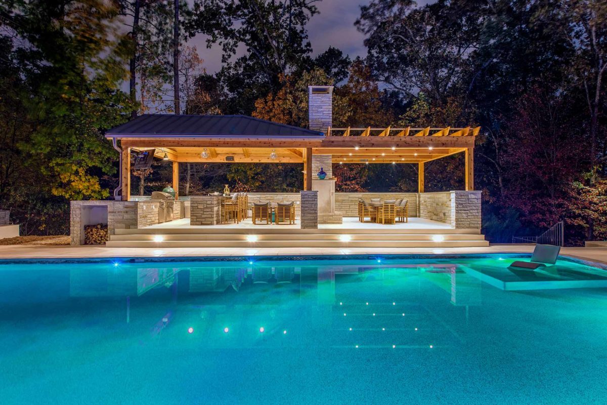 photo of a backyard pool design in PebbleTec Blue Lagoon Pool Finish medium blue water color in the evening