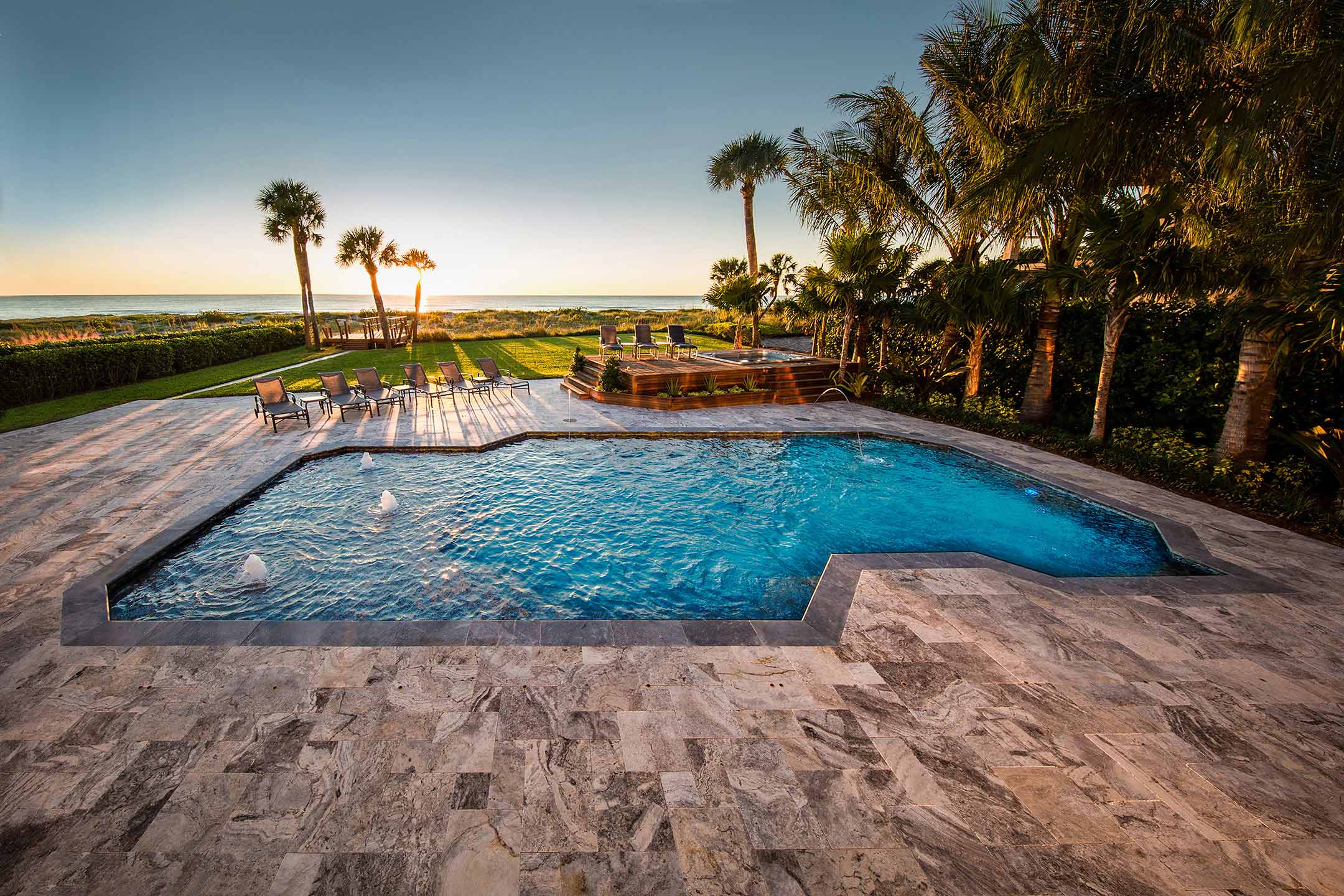 photo of PebbleTec PebbleBrilliance Crystal Harbor Pool Finish in a backyard with a sunset
