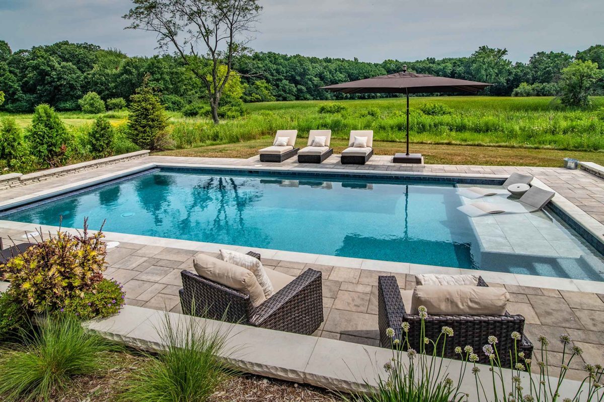 photo of a backyard pool design in PebbleTec Moonlight Grey Pool Finish medium blue water color by Barrington submitted for World's Greatest Pools 2018