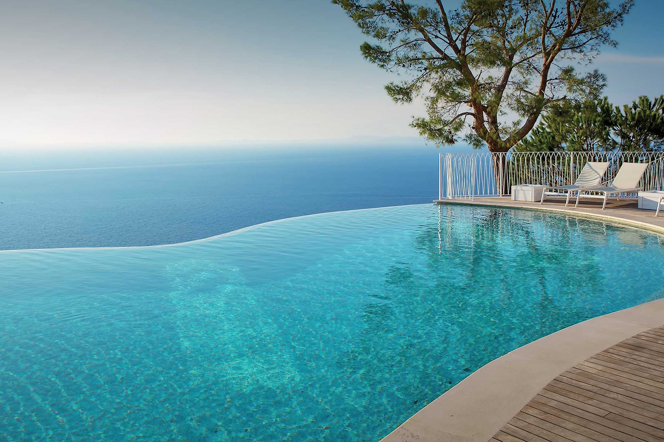 photo of a backyard waterfall pool design in PebbleTec White Pearl Pool Finish light blue water color by Prisport SAS submitted for World's Greatest Pools 2015