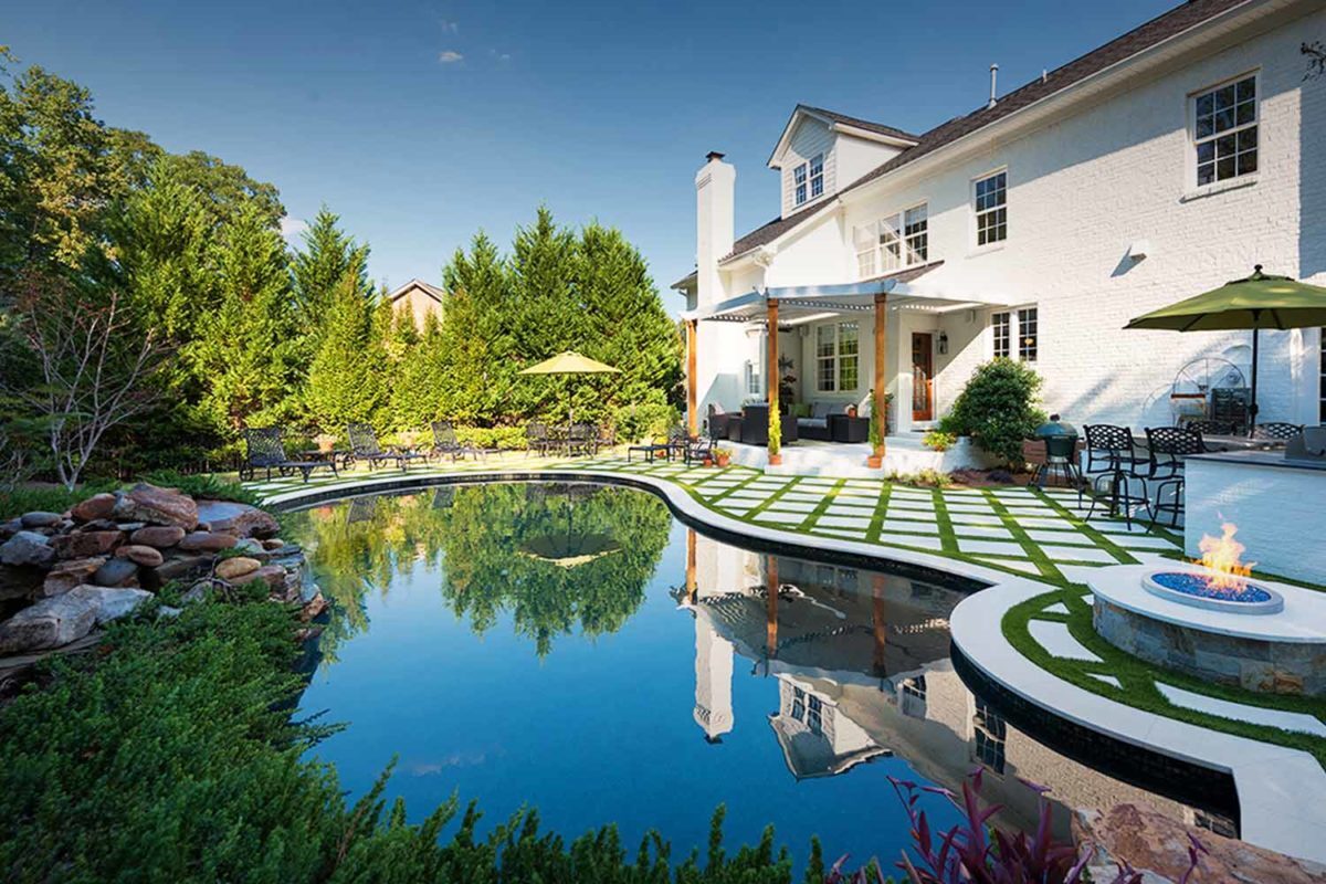 photo of a backyard pool design in PebbleTec Black Marble Pool Finish: A rich blend of white pebbles and a subtle metallic luster produce a deep dark blue water color.
