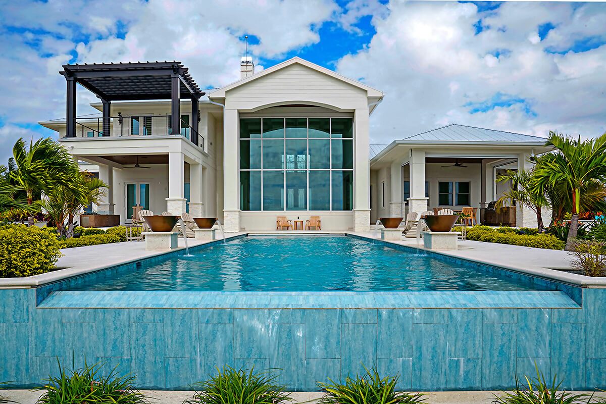 photo of a backyard pool design with a waterfall feature in PebbleTec Creme de Menthe Pool Finish medium blue water color