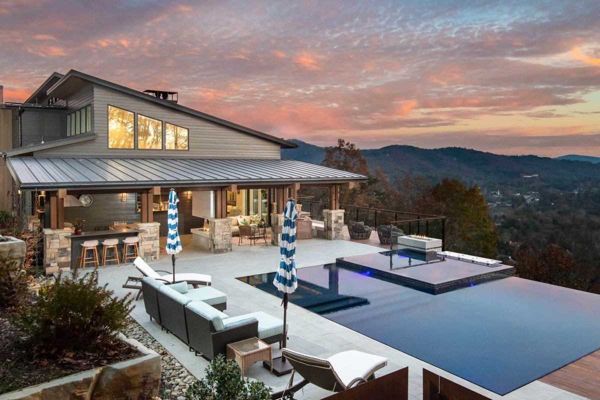 photo of a backyard waterfall pool design in PebbleTec PebbleBrilliance Majestic Sound Pool Finish with a sunset view of the mountains by Medallion submitted for World's Greatest Pools 2019