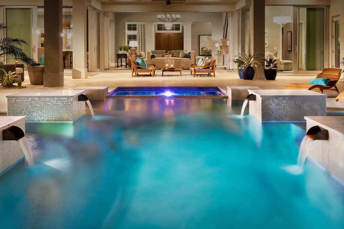 photo of a backyard pool design in PebbleTec Caribbean Blue Pool Finish by Coast to Coast with water features