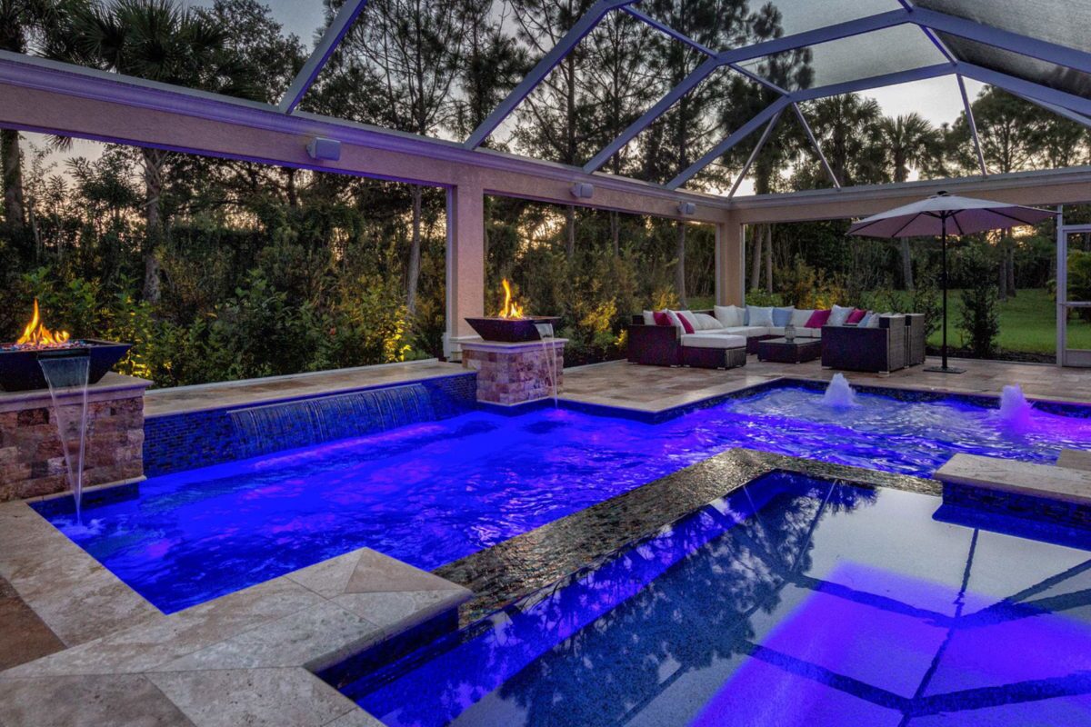photo of an indoor backyard pool design with Fire and Water bowl features and lightstreams tile in PebbleTec Blue Lagoon Pool Finish medium blue water color for World's Greatest Pools 2017