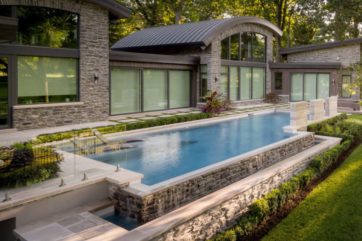 photo of a backyard lap pool design in PebbleTec Blue Wave Pool Finish with water features for World's Greatest Pools 2019