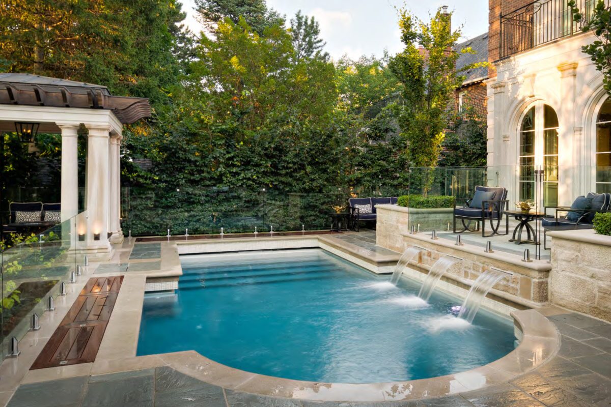 photo of a serene backyard pool design in PebbleTec Blue Wave Pool Finish medium blue water color with water features for World's Greatest Pools 2019