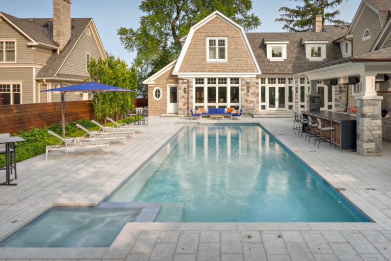 photo of a farmhouse backyard design with a pool and jacuzzi in PebbleTec Sky Blue Pool Finish for World's Greatest Pools 2019 in light blue water color