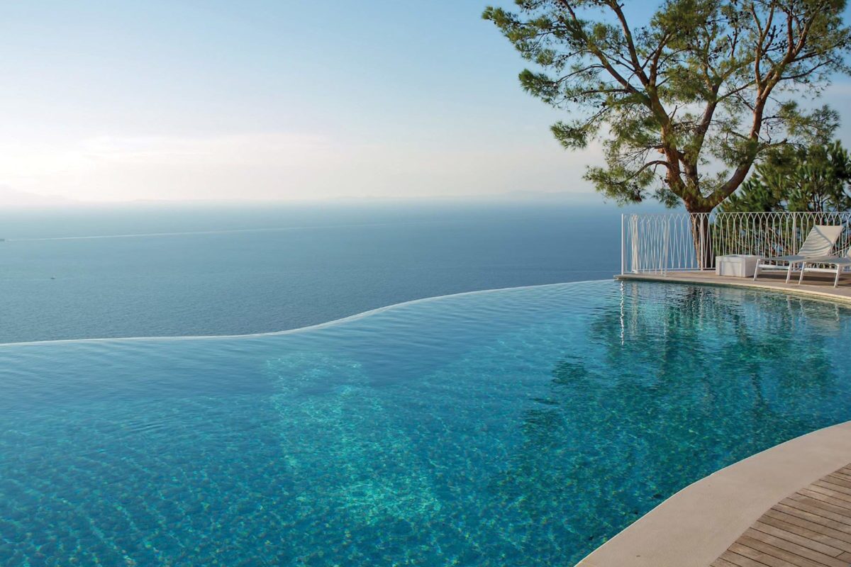 photo of a backyard waterfall pool design in PebbleTec White Pearl Pool Finish medium blue water color for World's Greatest Pools 2015