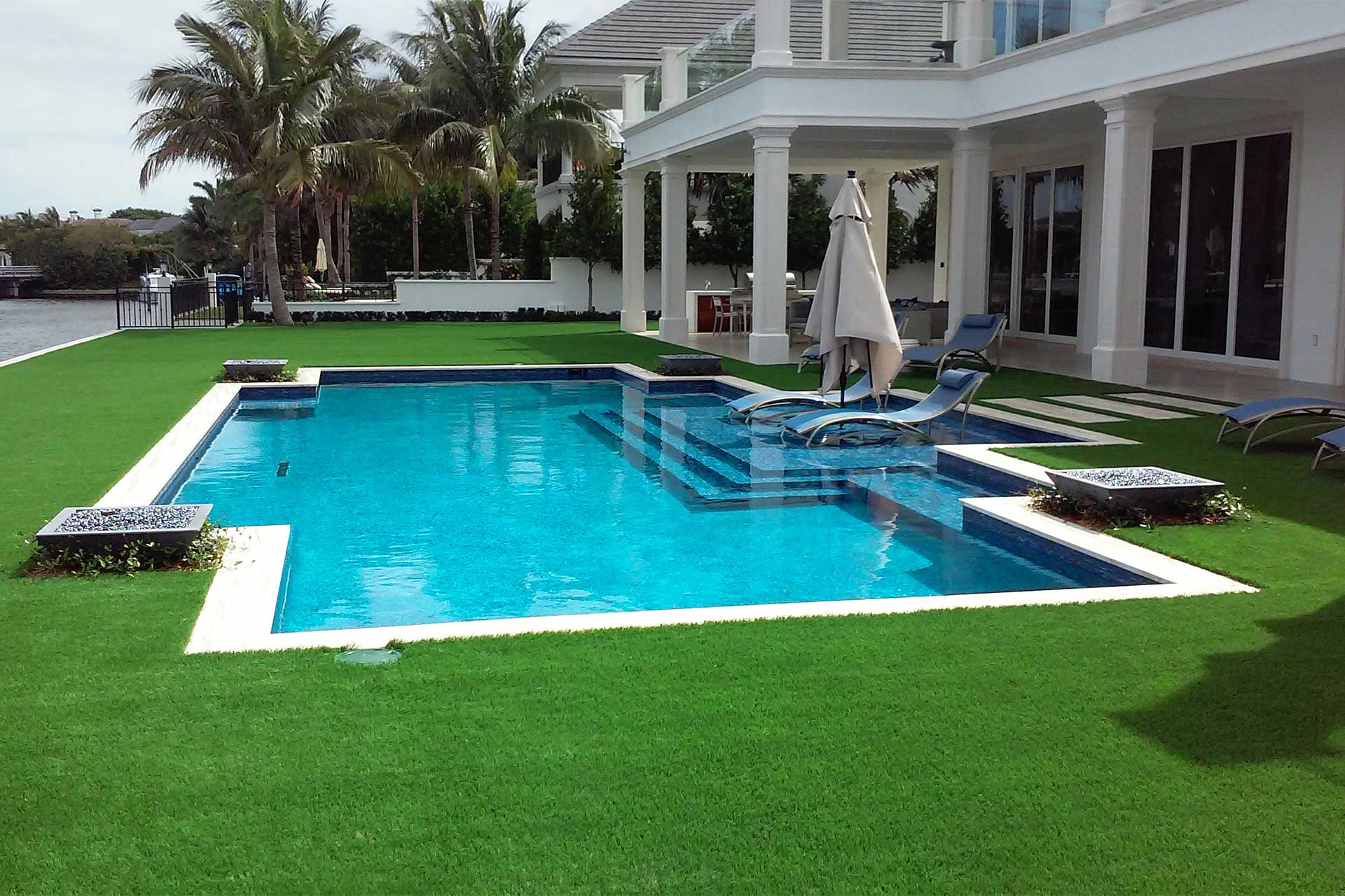 photo of a backyard pool design on the river in PebbleBreeze Fresh Water Pool Finish medium blue water color and fire bowls by Star Light Pool Builders for 2016 World's Greatest Pools