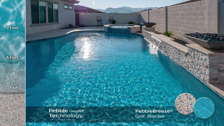 photo of backyard pool with water feature and fire bowl in PebbleBreeze Silver Sea water color pool finish at Casillas home