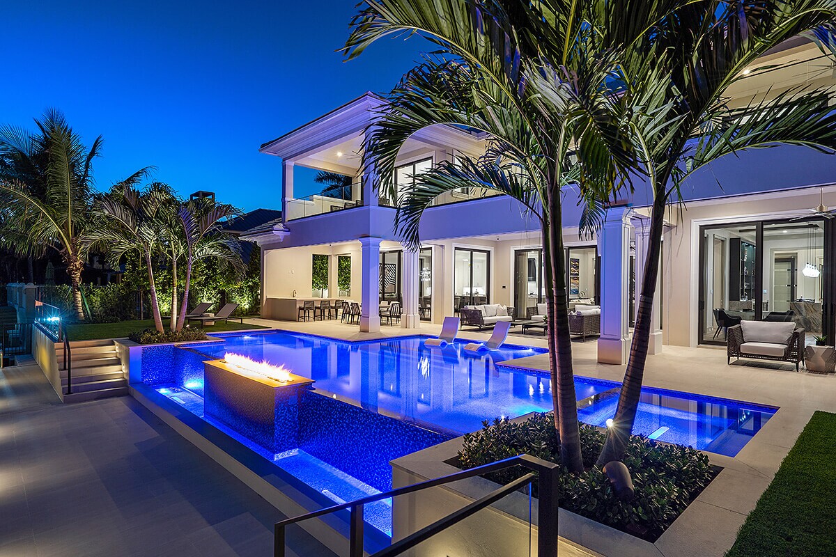 photo of a backyard pool design at a mansion in PebbleTec PebbleBrilliance Deep Cove Pool Finish medium blue water color with a fire feature by Star Lite Pool Builders submitted for World's Greatest Pools 2021