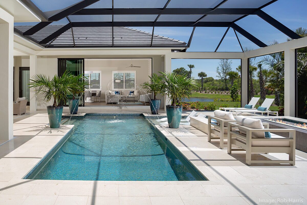 photo of a backyard waterfall pool design in PebbleTec Caribbean Blue Pool Finish medium blue water color with lightstreams tile and water features